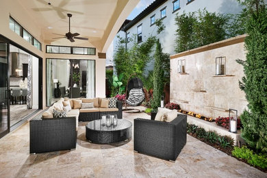 Photo of a small modern side yard patio in Orlando with a fire feature, a roof extension and natural stone pavers.