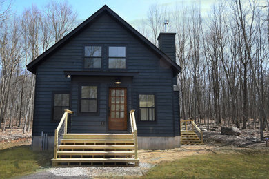 Inspiration for a mid-sized farmhouse black two-story wood exterior home remodel in New York with a metal roof