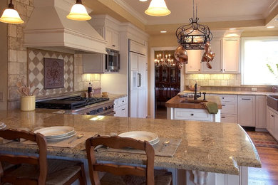 Inspiration for a large timeless u-shaped light wood floor open concept kitchen remodel in San Francisco with a farmhouse sink, raised-panel cabinets, white cabinets, wood countertops, beige backsplash, stone tile backsplash, paneled appliances and an island