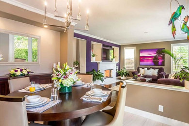 Example of a large porcelain tile dining room design in Los Angeles with beige walls, a ribbon fireplace and a tile fireplace