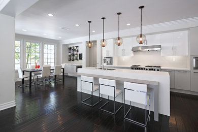 Inspiration for a mid-sized contemporary galley open plan kitchen in Atlanta with an undermount sink, quartz benchtops, grey splashback, porcelain splashback, stainless steel appliances, dark hardwood floors, with island, flat-panel cabinets and grey cabinets.