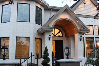 Large modern white two-story exterior home idea in Vancouver with a shingle roof