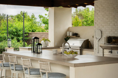 Modelo de patio mediterráneo grande en patio trasero con cocina exterior, suelo de baldosas y cenador