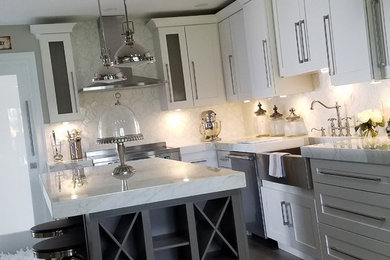 Eat-in kitchen - shabby-chic style light wood floor and brown floor eat-in kitchen idea in Other with a farmhouse sink, shaker cabinets, white cabinets, white backsplash, stainless steel appliances and an island