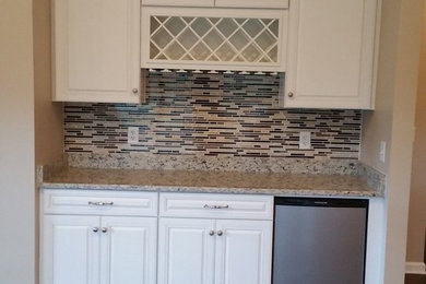 Inspiration for a large transitional u-shaped medium tone wood floor and brown floor eat-in kitchen remodel in Philadelphia with an undermount sink, raised-panel cabinets, white cabinets, laminate countertops, brown backsplash, mosaic tile backsplash, stainless steel appliances and a peninsula