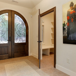 Imagen de hall mediterráneo, de tamaño medio, con paredes beige, suelo vinílico, puerta doble, puerta de madera en tonos medios y suelo beige