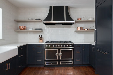デトロイトにある高級な小さなコンテンポラリースタイルのおしゃれなキッチン (エプロンフロントシンク、シェーカースタイル扉のキャビネット、黒いキャビネット、クオーツストーンカウンター、白いキッチンパネル、サブウェイタイルのキッチンパネル、黒い調理設備、無垢フローリング、アイランドなし) の写真