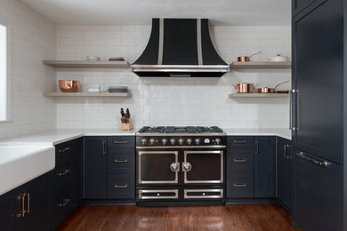 Eat-in kitchen - small contemporary l-shaped medium tone wood floor eat-in kitchen idea in Detroit with a farmhouse sink, shaker cabinets, black cabinets, quartz countertops, white backsplash, subway tile backsplash, black appliances and no island