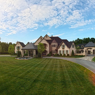 他の地域のトラディショナルスタイルのおしゃれな家の外観 (アドベサイディング、ベージュの外壁) の写真