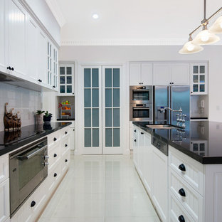 Large traditional kitchen pantry appliance - Kitchen pantry - large traditional galley porcelain floor kitchen pantry idea in Gold Coast - Tweed with a double-bowl sink, shaker cabinets, white cabinets, granite countertops, white backsplash, cement tile backsplash, stainless steel appliances and an island