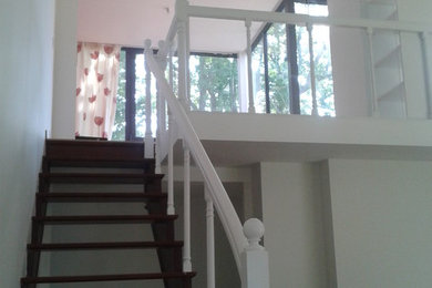 Diseño de escalera recta grande con escalones de madera y barandilla de vidrio