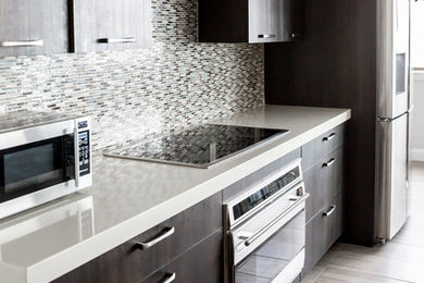 Eat-in kitchen - large contemporary u-shaped porcelain tile eat-in kitchen idea in Salt Lake City with an undermount sink, flat-panel cabinets, dark wood cabinets, marble countertops, blue backsplash, mosaic tile backsplash, stainless steel appliances and a peninsula