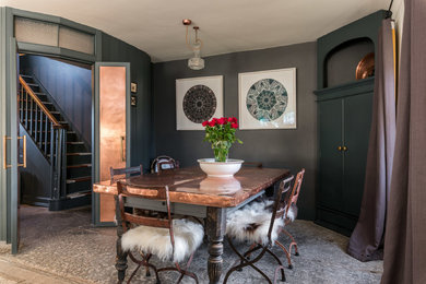 This is an example of a mid-sized industrial dining room in Other with black walls and grey floor.