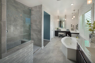 Photo of a large contemporary master bathroom in Los Angeles with medium wood cabinets, a freestanding tub, a corner shower, white walls, porcelain floors, an integrated sink, recessed-panel cabinets, gray tile, porcelain tile, solid surface benchtops, grey floor and a hinged shower door.