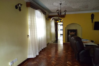 Mid-sized minimalist formal and enclosed dark wood floor living room photo in Other with yellow walls and a wall-mounted tv