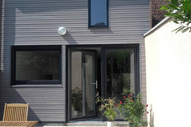 Réalisation d'une façade de maison design en bois avec un toit en appentis et un toit mixte.