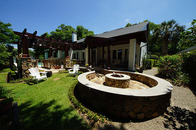 Patio - mid-sized southwestern front yard stone patio idea in Orlando with a roof extension