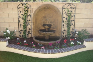 Photo of a small mediterranean shade backyard brick water fountain landscape in Los Angeles for spring.