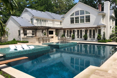 Large transitional backyard stone and rectangular pool photo in Kansas City