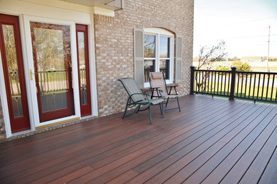Mid-sized traditional front yard verandah in Other with decking.