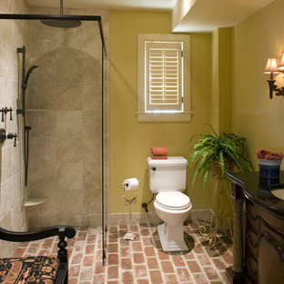 Aménagement d'une salle de bain classique avec un mur jaune et un sol en brique.