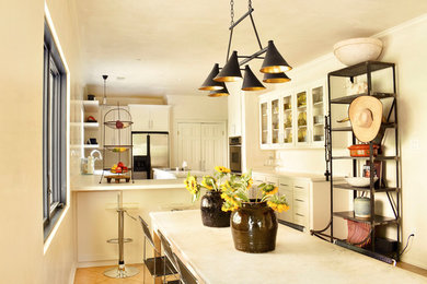 Mid-sized trendy u-shaped porcelain tile and beige floor eat-in kitchen photo in Houston with a farmhouse sink, shaker cabinets, white cabinets, quartzite countertops, stainless steel appliances, an island and white countertops