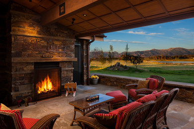 Patio - large traditional backyard stone patio idea in Other with a roof extension