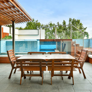 Mid-sized contemporary patio in Brisbane with an outdoor kitchen, natural stone pavers and a pergola.