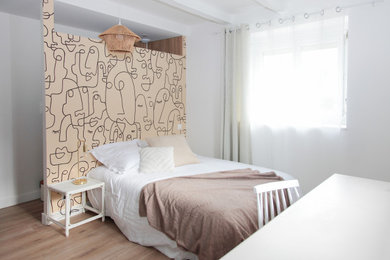 Idée de décoration pour une chambre d'amis beige et blanche méditerranéenne de taille moyenne avec un mur blanc, parquet clair, aucune cheminée et un sol marron.