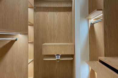 Walk-in closet - mid-sized modern gender-neutral light wood floor and beige floor walk-in closet idea in New York with open cabinets and light wood cabinets