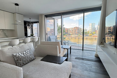 Mittelgroßes, Repräsentatives, Offenes Modernes Wohnzimmer in grau-weiß mit beiger Wandfarbe, dunklem Holzboden, TV-Wand und grauem Boden in Hamburg