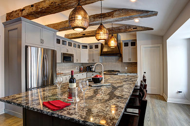 Mid-sized country l-shaped medium tone wood floor eat-in kitchen photo in Toronto with an undermount sink, shaker cabinets, gray cabinets, granite countertops, gray backsplash, subway tile backsplash, stainless steel appliances and an island