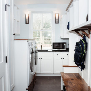 Inspiration for a medium sized classic l-shaped utility room in Burlington with a submerged sink, shaker cabinets, white cabinets, soapstone worktops, blue walls, porcelain flooring, a side by side washer and dryer, brown floors and black worktops.