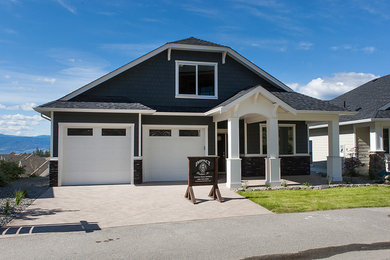 Inspiration for a mid-sized transitional blue house exterior remodel in Vancouver with a clipped gable roof