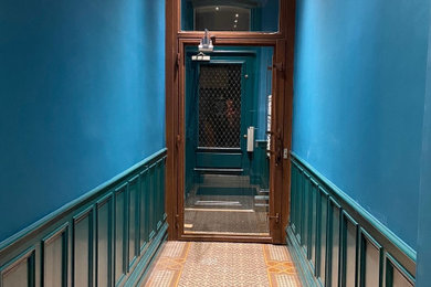 Cette photo montre un grand couloir chic en bois avec un mur bleu, un sol en carrelage de porcelaine, un sol multicolore et un plafond en bois.
