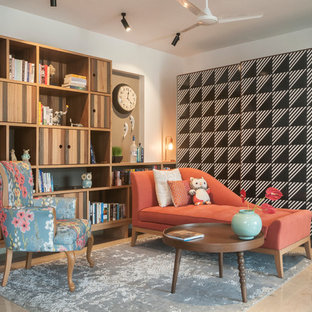 Esempio di un piccolo soggiorno eclettico con libreria, pareti bianche e pavimento beige