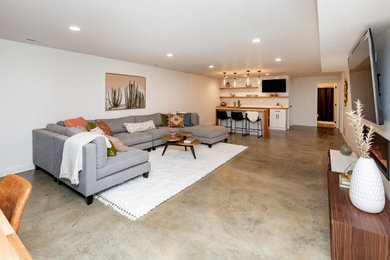 Basement - mid-sized modern underground concrete floor basement idea in Other with white walls and a standard fireplace
