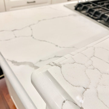Ivory White Kitchen With Marble Look Quartz Counters and Splash