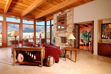 Inspiration for a southwestern marble floor living room remodel in Albuquerque with beige walls, a two-sided fireplace and a stone fireplace