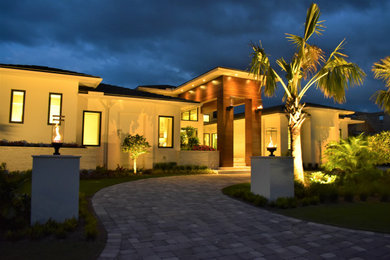Example of a mid-sized trendy white one-story mixed siding house exterior design in Miami with a hip roof, a tile roof and a gray roof