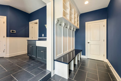 Large cottage laminate floor, blue floor, vaulted ceiling and wall paneling mudroom photo in DC Metro with blue walls