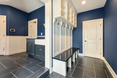 Photo of a large rural boot room in DC Metro with blue walls, laminate floors, blue floors, a vaulted ceiling and panelled walls.