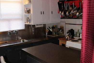 Small white floor kitchen photo in Toronto with white cabinets, white backsplash, white appliances and an island