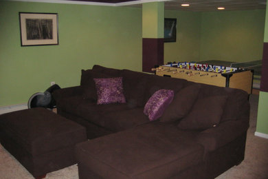 Photo of a mid-sized contemporary walk-out basement in Other with green walls and carpet.