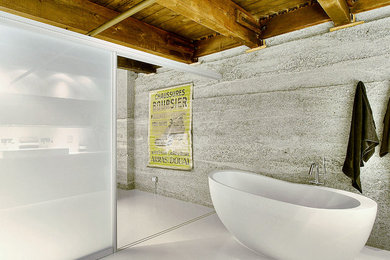 Photo of a country bathroom in Hamburg with a freestanding tub and grey walls.