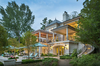 Mid-sized tuscan beige three-story concrete house exterior photo in Other with a mixed material roof