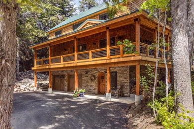 Mid-sized mountain style two-story wood and shingle exterior home photo in Seattle with a metal roof