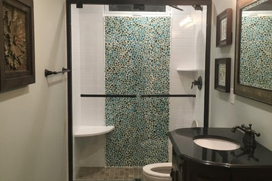 Photo of a mid-sized transitional 3/4 bathroom in Philadelphia with furniture-like cabinets, dark wood cabinets, an alcove shower, multi-coloured tile, mosaic tile, beige walls, porcelain floors, an undermount sink, solid surface benchtops, multi-coloured floor and a sliding shower screen.
