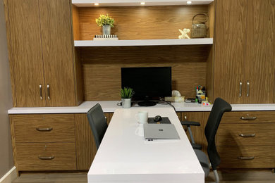 Home office - mid-sized modern built-in desk laminate floor home office idea in Montreal