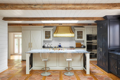 Example of a mid-sized eclectic l-shaped terra-cotta tile and orange floor open concept kitchen design in Nashville with recessed-panel cabinets, blue cabinets, white backsplash, paneled appliances, an island, an undermount sink, quartzite countertops and ceramic backsplash